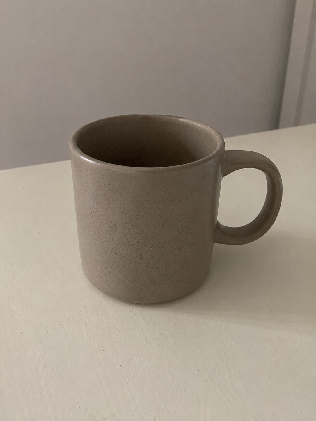 A plain phone photo of a ceramic mug on a table before Veyio.